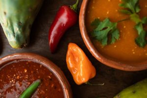 A colorful display of Mexican food featuring chili peppers and sauces.
